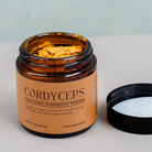 Cordyceps militaris mushroom extract in opened glass jar showing the bright orange powder. By Nature's Antidote.