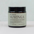 A glass jar of Sri Lankan moringa leaf powder with a black lid and an elegant label, featuring Nature's Antidote branding.